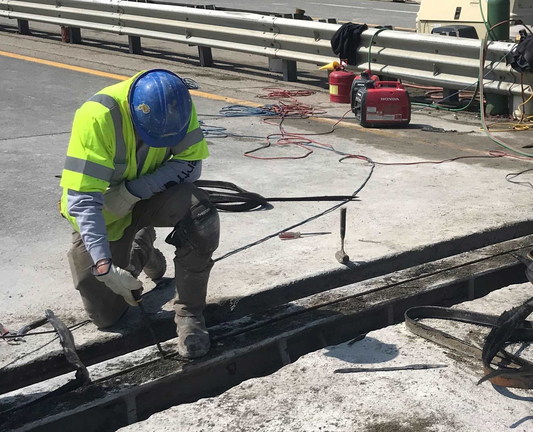 A-worker-removes-old-portions-of-a-bridge-in-April-2025.jpg